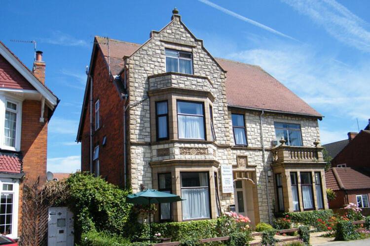 een groot bakstenen huis met een paraplu ervoor bij Kinda Apartments in Skegness