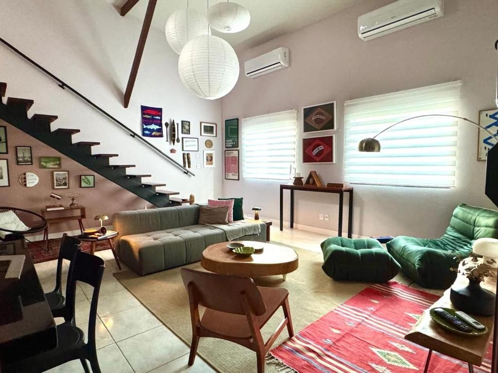 een woonkamer met een bank en een trap bij Descubra a Casa Felicidade em Belém! Climatizada, com sala ampla, 2 quartos, mezanino e Wi-Fi veloz. Localização central perto de atrações e gastronomia. Viva a Amazônia com conforto exclusivo. Reserve já sua experiência inesquecível! in Curro Velho