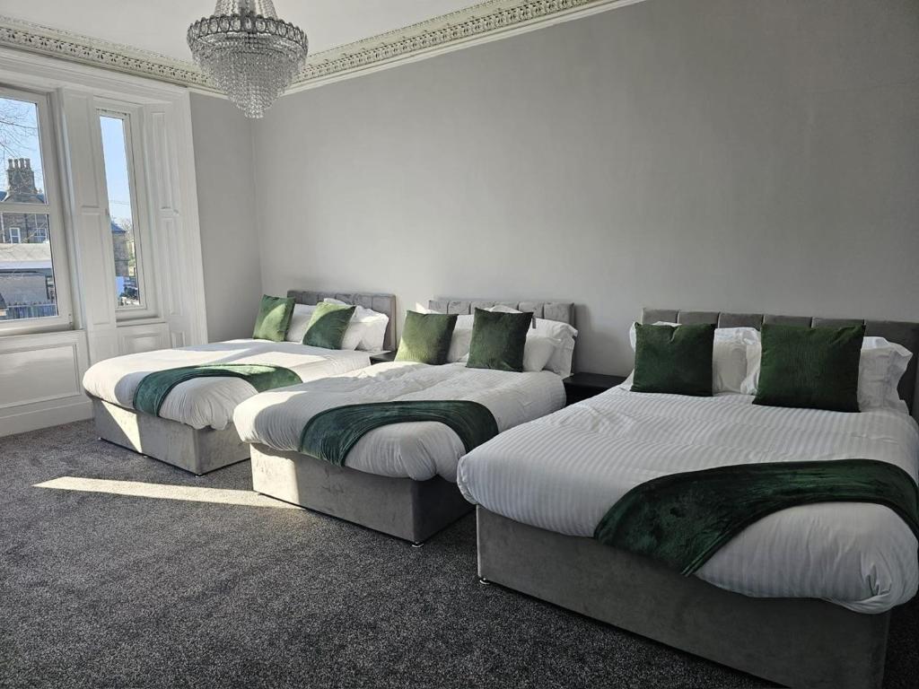 爱丁堡Central Hotel Edinburgh的带绿色枕头的三张床