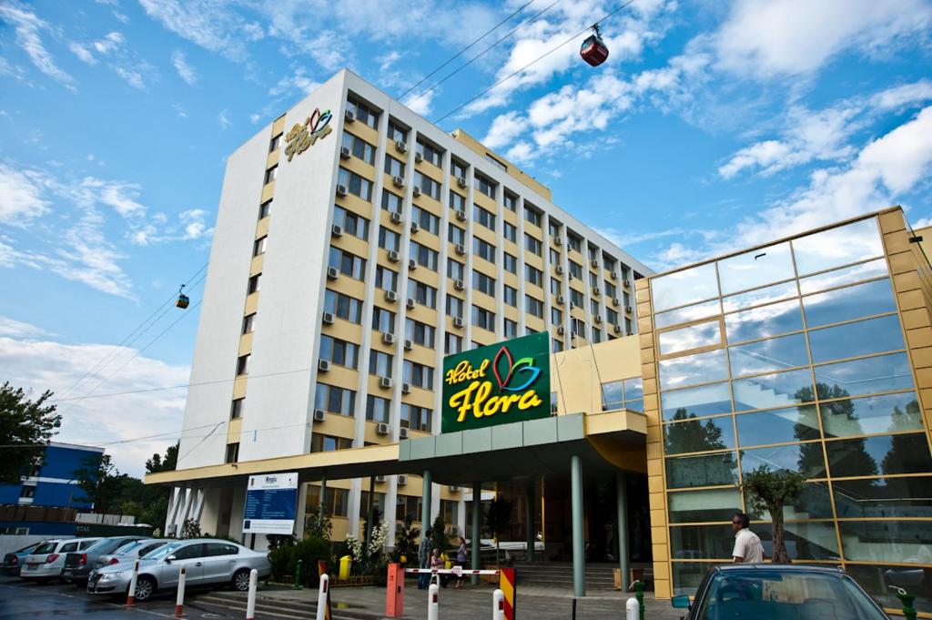 een groot hotelgebouw met een vlieger in de lucht bij Hotel Flora in Mamaia