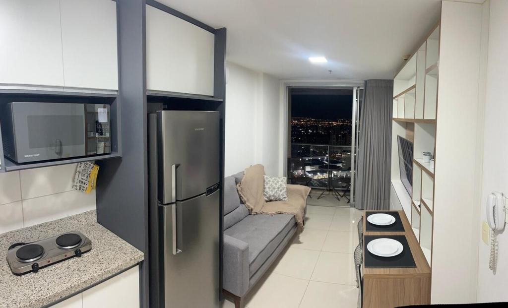 a living room with a couch and a refrigerator at Apartamento vista privilegiada, DF PLAZA in Brasilia