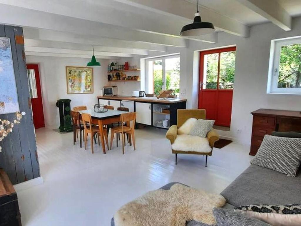 a kitchen and living room with a table and chairs at Maison charmante au calme avec jardin à Kerlard - FR-1-813-24 in Groix