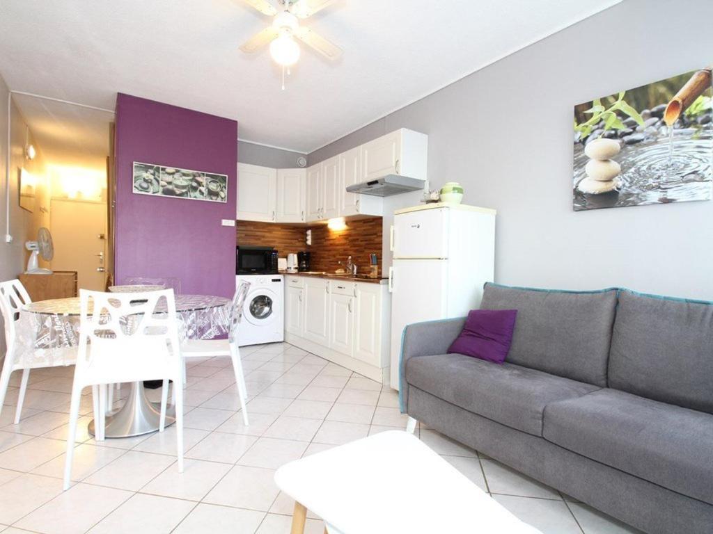 un salon avec un canapé et une table et une cuisine dans l'établissement T1 rénové avec goût, proche Thermes, avec WiFi - FR-1-553-302, à Balaruc-les-Bains