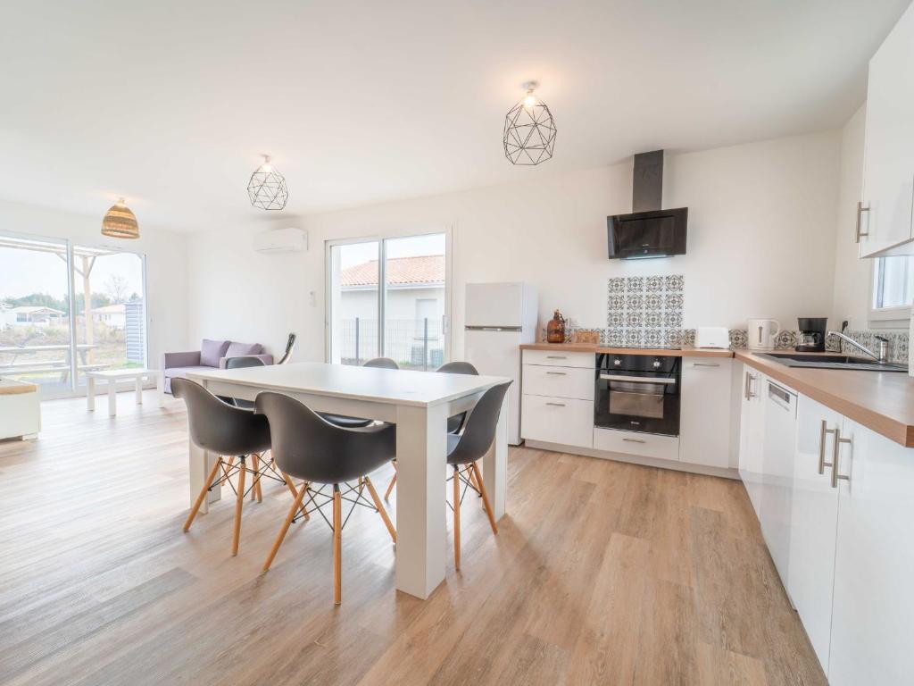 a kitchen and dining room with a table and chairs at Maison neuve pour 4 personnes proche Mimizan - Climatisation incluse - FR-1-50-169 in Saint-Paul-en-Born