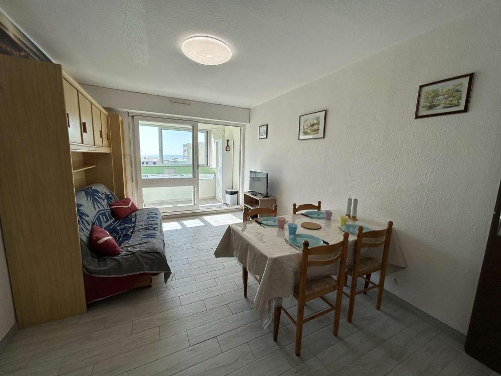 un salon avec une table et un canapé dans l'établissement Appartement lumineux 2 pièces, proche plage, parking inclus - FR-1-224C-339, à Saint-Hilaire-de-Riez