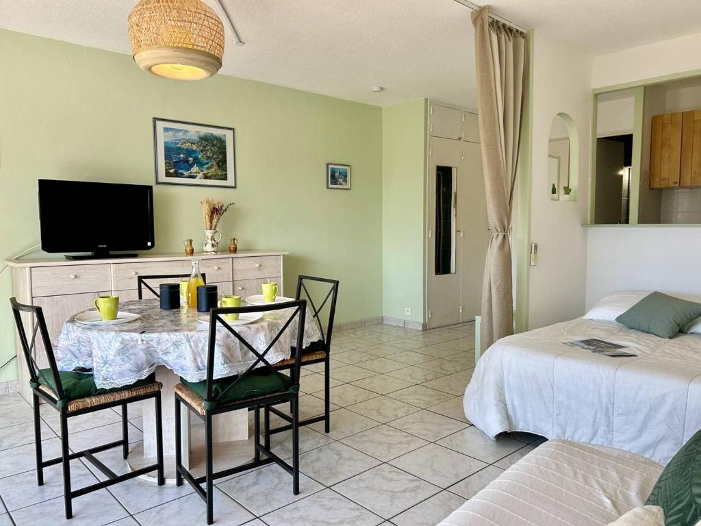 un salon avec une table et un lit dans l'établissement Studio au Lavandou, Terrasse, Climatisation, Proche Plage - FR-1-251-857, au Lavandou