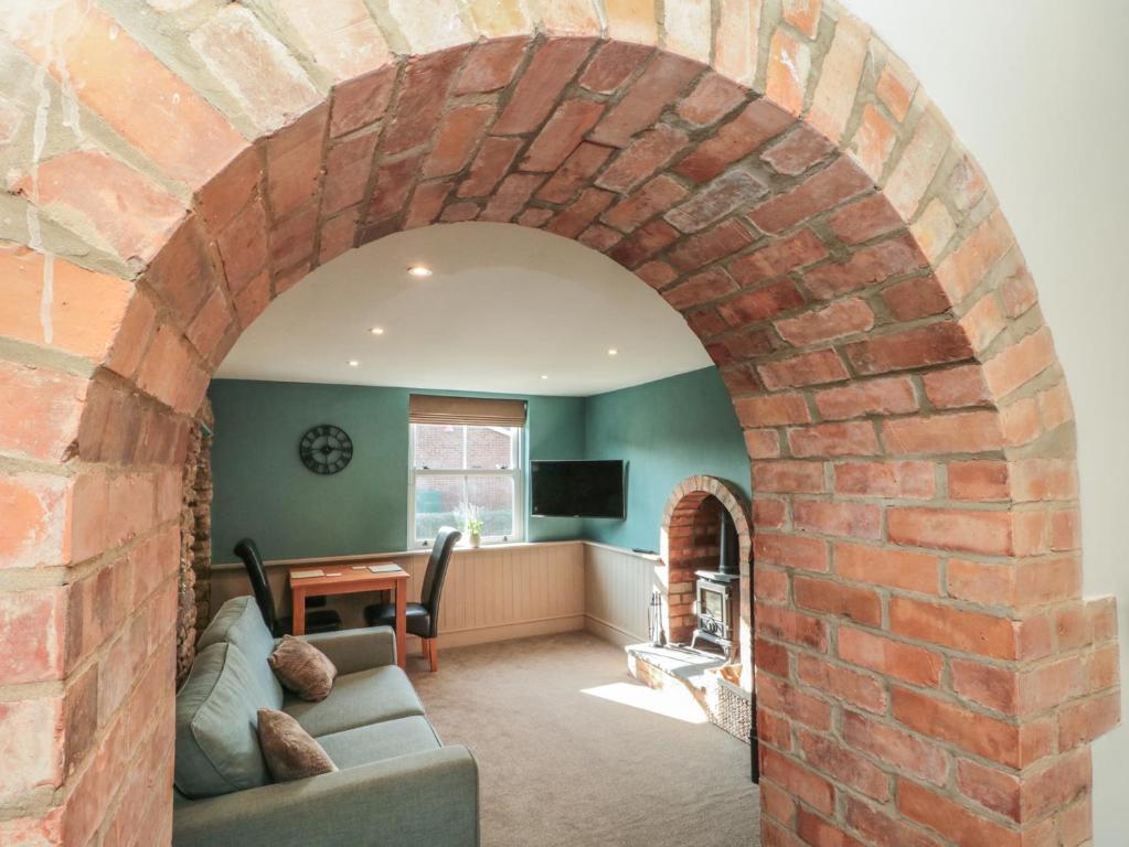 an archway in a living room with a brick wall at Top Holme Cottage in York