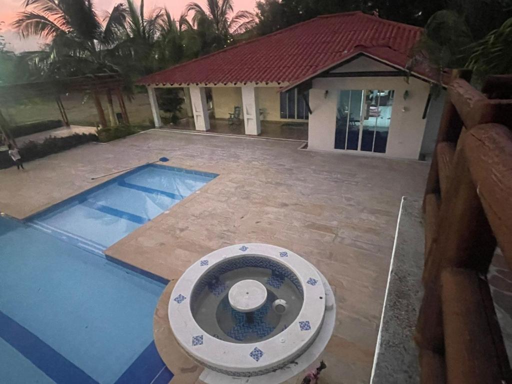 a swimming pool in front of a house at Hacienda Villa Hermelina-Casa Campestre in Turbaco