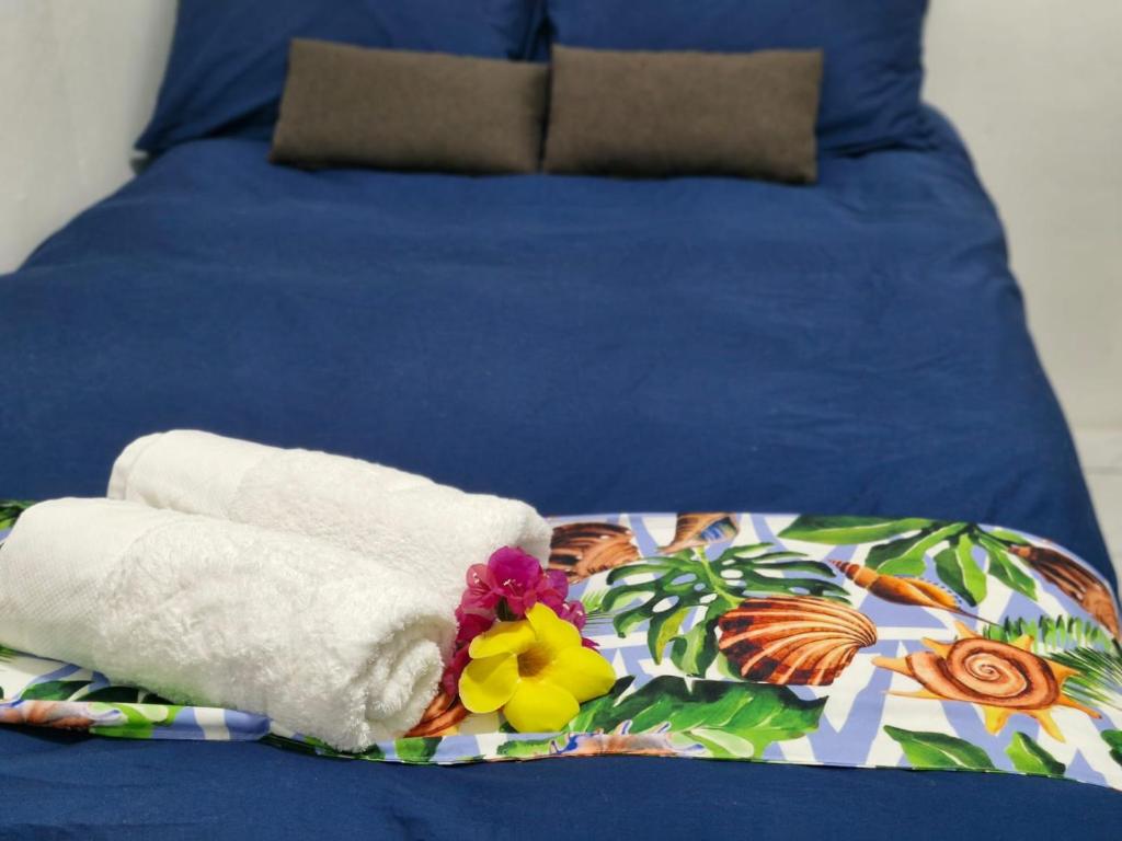 - un lit avec 2 serviettes et des fleurs dans l'établissement JetPoint Family Home, à Nadi