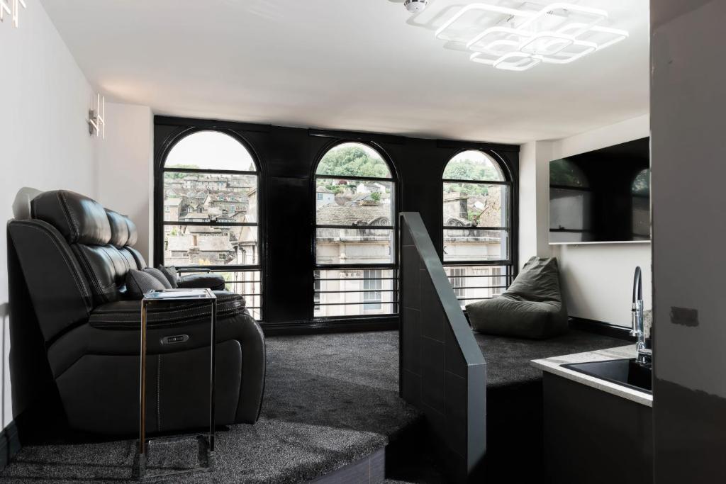 a living room with a couch and some windows at The Residence in Kendal
