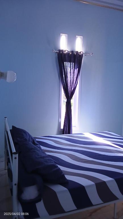 a bedroom with a bed with a curtain and a window at Uoemah gunung baturaden in Baturaden