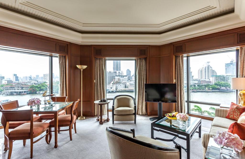 a living room with a view of the water at The Peninsula Bangkok in Bangkok