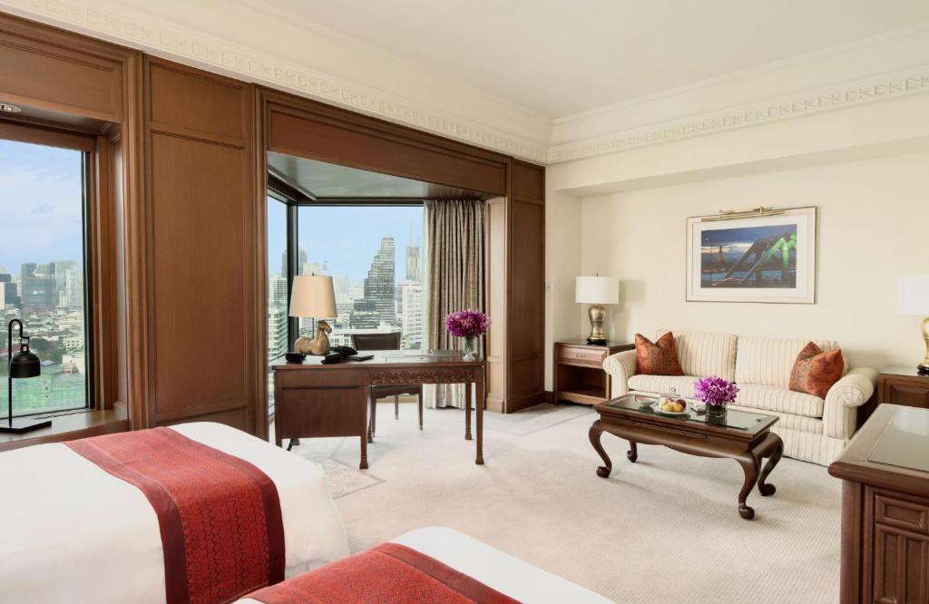 a hotel room with a bed and a desk at The Peninsula Bangkok in Bangkok