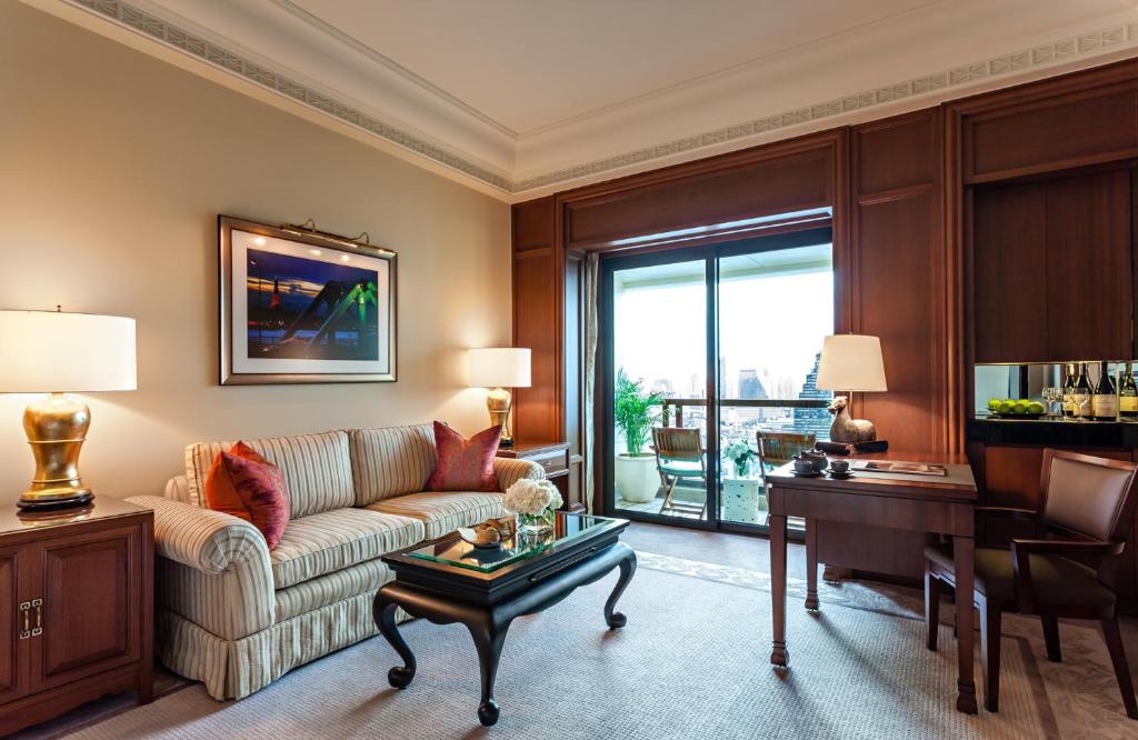 a living room with a couch and a table at The Peninsula Bangkok in Bangkok