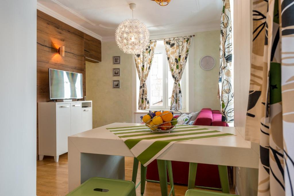 a dining room with a table with a bowl of fruit on it at Apartments Petra in Dubrovnik