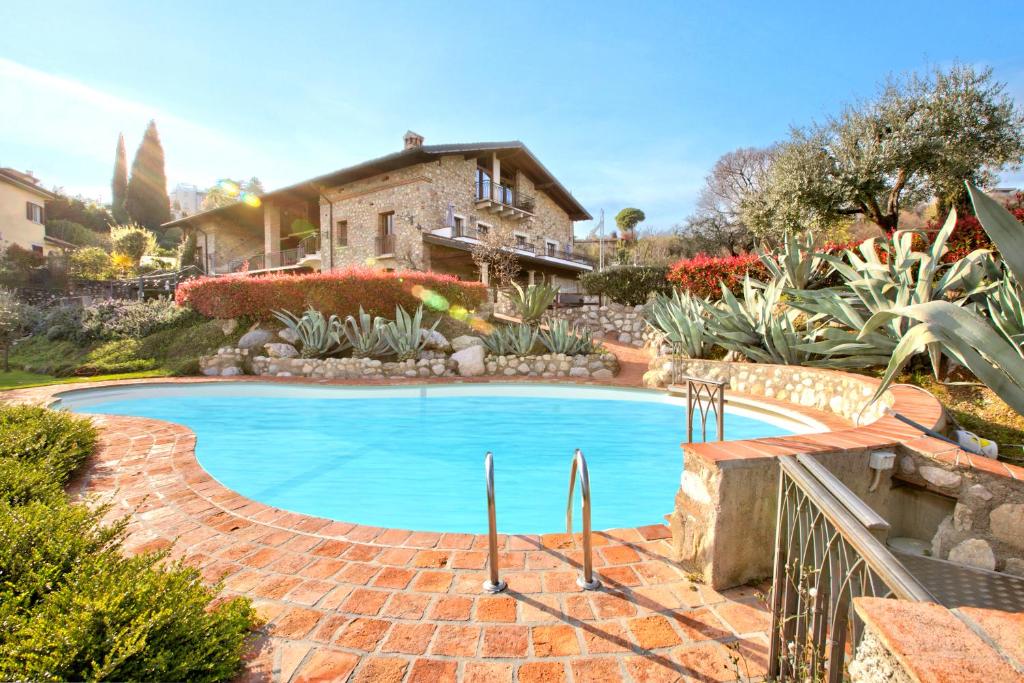 a swimming pool in front of a house at Agriturismo Cascina Crocelle - Lake View and Heated Pool in Padenghe sul Garda