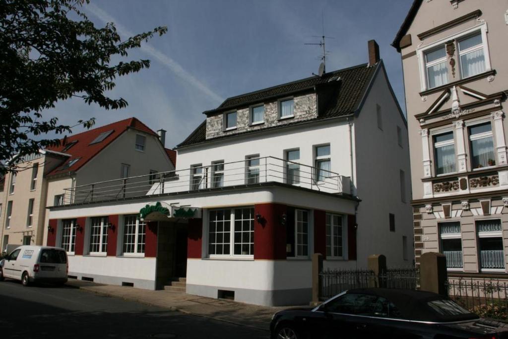 duży biały dom z czerwonymi drzwiami w obiekcie Hotel Diening w Essen