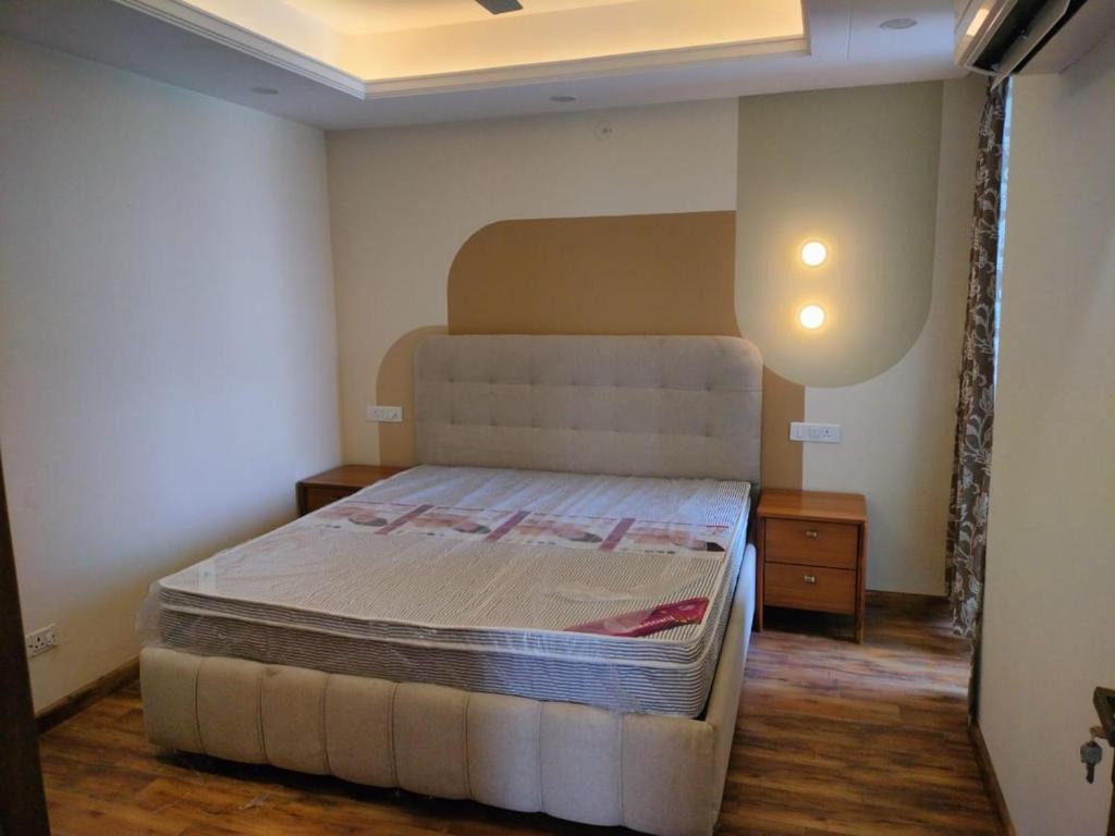 德拉敦Flat in Dehradun的一间带床和床头柜的小卧室