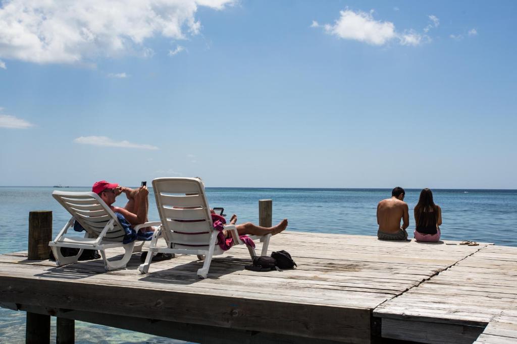 a group of people sitting in chairs on a dock at Splash Inn Dive Resort & Villas in West End