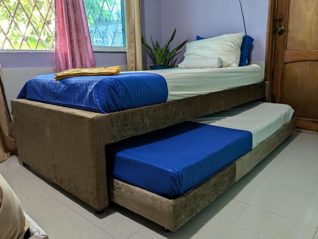 two beds in a room with blue cushions at Me Quedo Aqui, Casa Cerca del Aeropuerto de Cartagena! in Cartagena de Indias