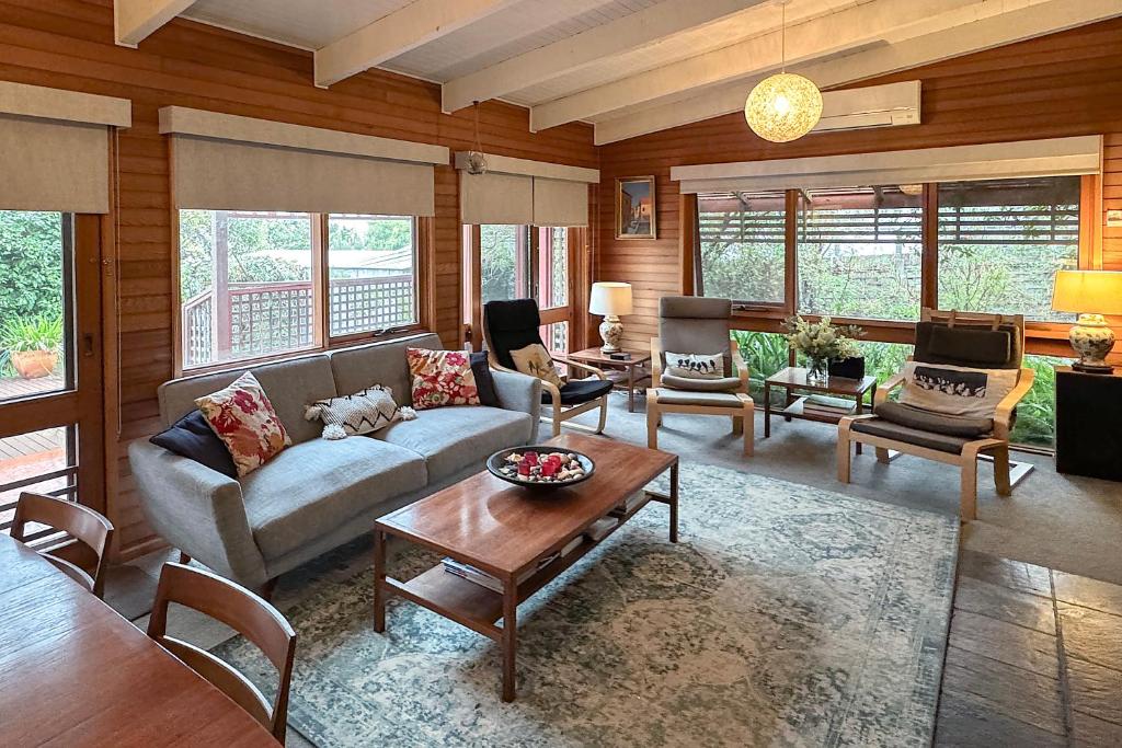 un salon avec un canapé et une table dans l'établissement Anchorage Cottage Ventnor, Phillip Island - pet friendly, free WiFi, linen included, à Ventnor