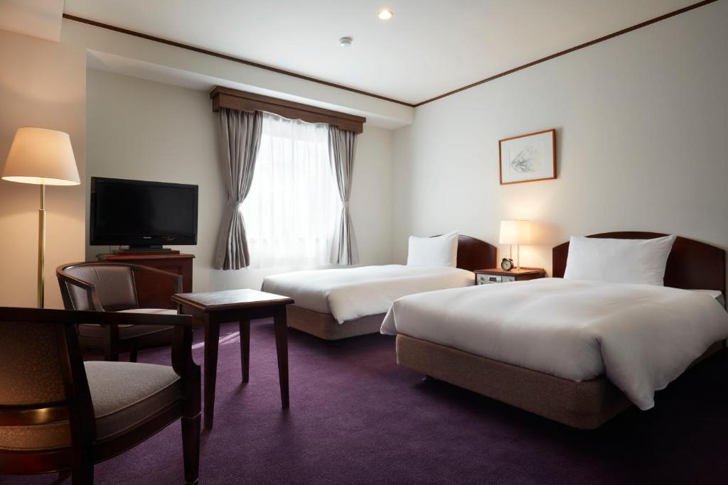 Кровать или кровати в номере Matsumoto Hotel Kagetsu