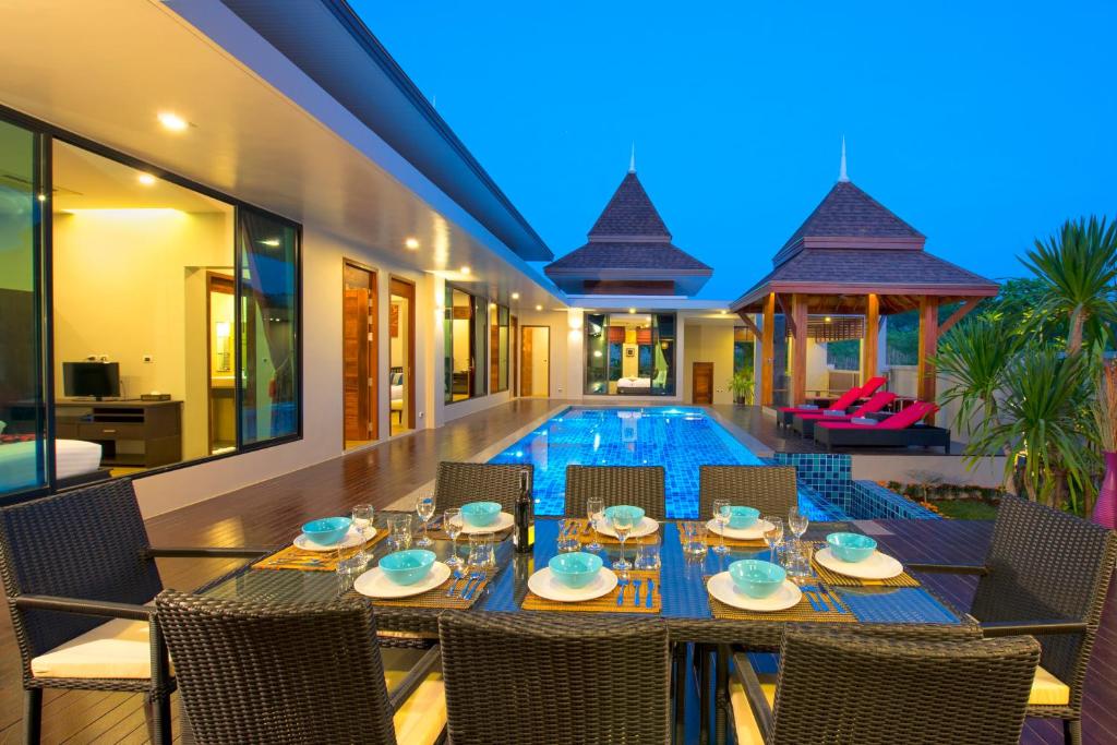 a dining room with a table and chairs next to a pool at Narintara Private Pool Villas - FREE Tuk-Tuk Service to the Beach! in Ao Nang Beach