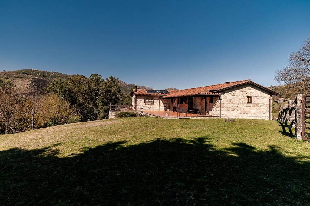 a house sitting on top of a grassy hill at Turismo Rural No Gerês in Carvalheira