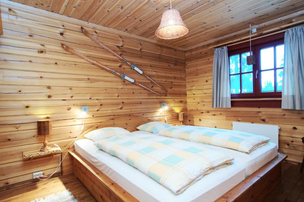 a bedroom with a wooden wall with a bed in it at Galå Fjällgård in Galåbodarna
