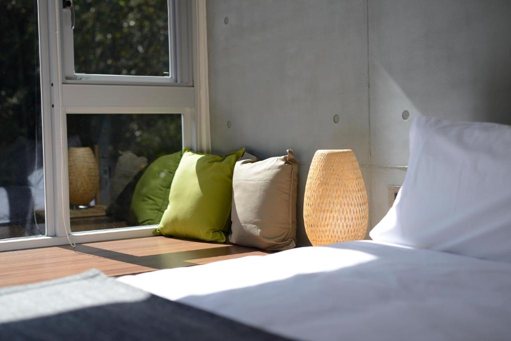 a bedroom with a bed with pillows and a window at 日月潭山慕藝旅 Sun Moon Inn in Yuchi