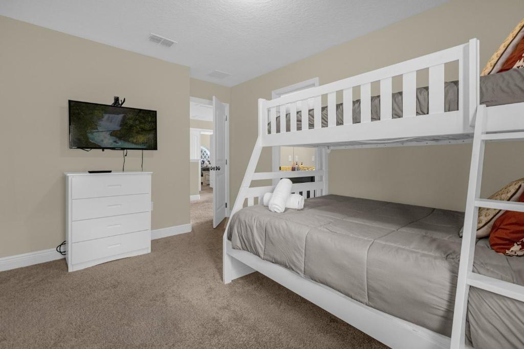 a bedroom with two bunk beds and a television at 5259-6-WW-Pool&SPA Lazy River&Slides in Davenport