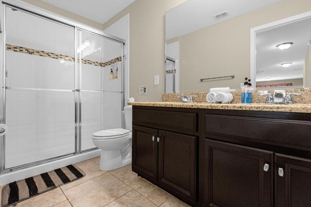 a bathroom with a shower and a toilet and a sink at 5259-6-WW-Pool&SPA Lazy River&Slides in Davenport