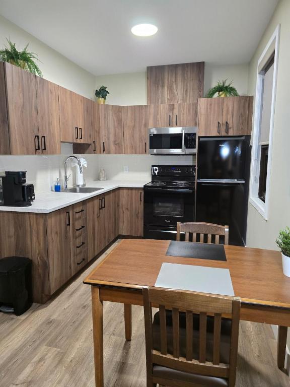 a kitchen with wooden cabinets and a table and a black appliance at Cozy Maison Apt #8 in Gatineau