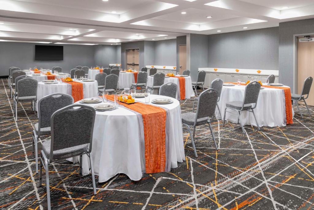 a conference room with tables and chairs and a screen at Hampton Inn Olathe in Olathe