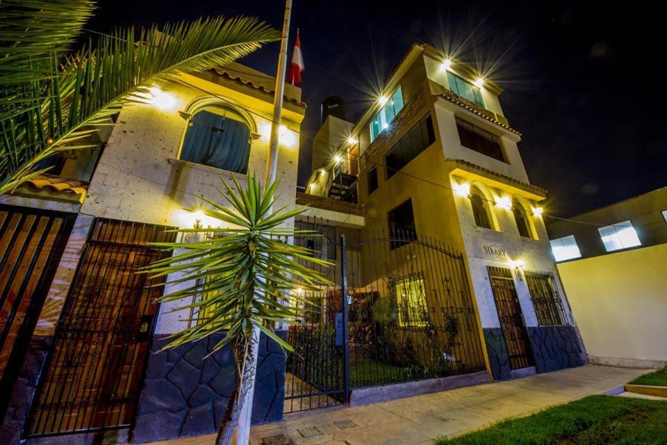 budynek z palmą przed nim w obiekcie Sillary Hostal Boutique w mieście Arequipa