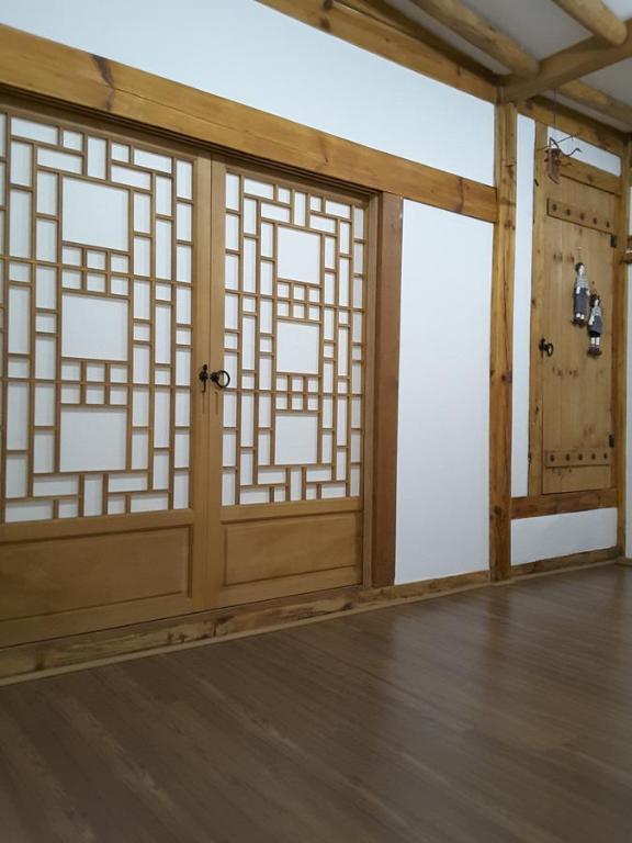 Zimmer mit Holztüren und Holzboden in der Unterkunft Yettle Hanok Stay in Gyeongju