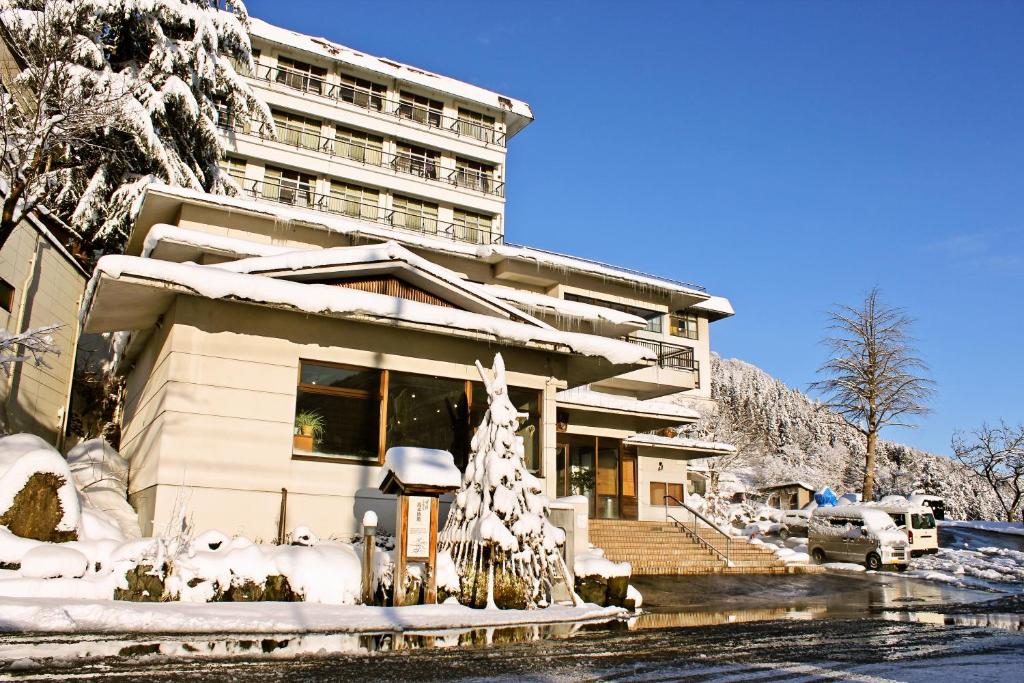 um edifício coberto de neve com um edifício em Takahan em Yuzawa