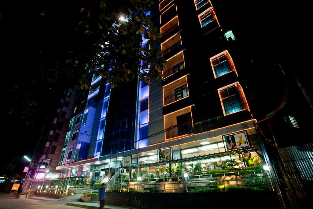 un edificio con luces azules en el lateral. en Well Park Residence Boutique Hotel & Suites, en Chittagong