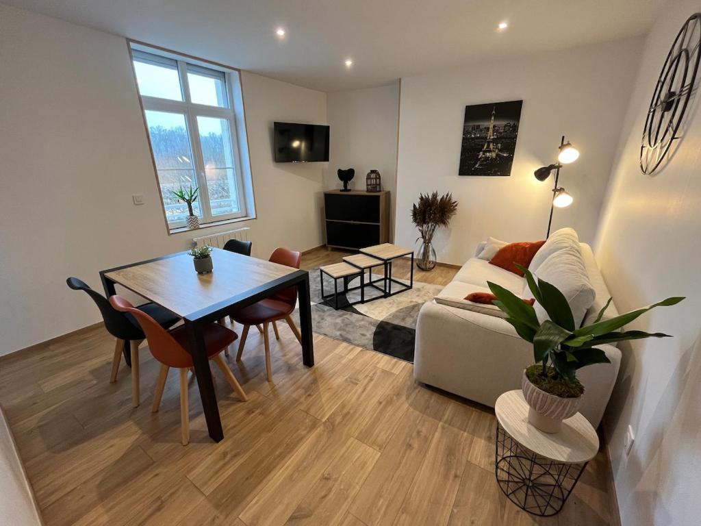 a living room with a table and a couch at Appart Cosy II in Hesdin