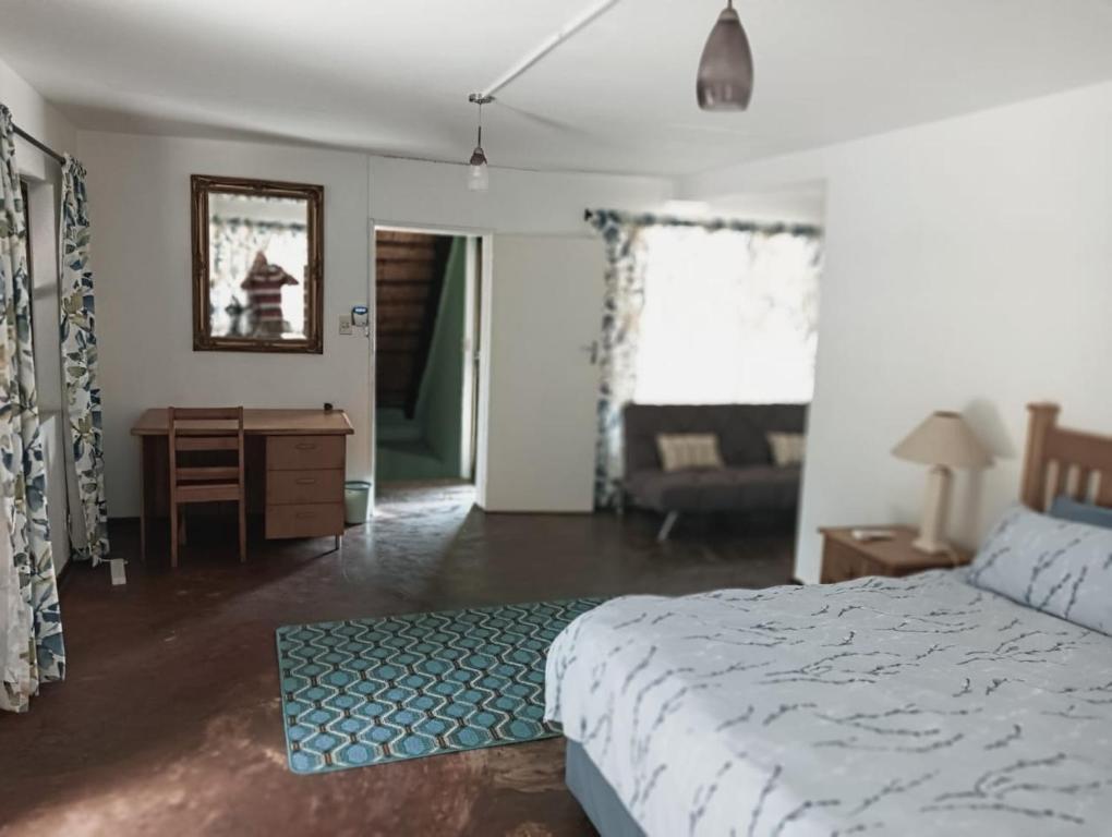 a bedroom with a bed and a desk and a chair at Pennington Beach Cottage Holiday accommodation in Pennington