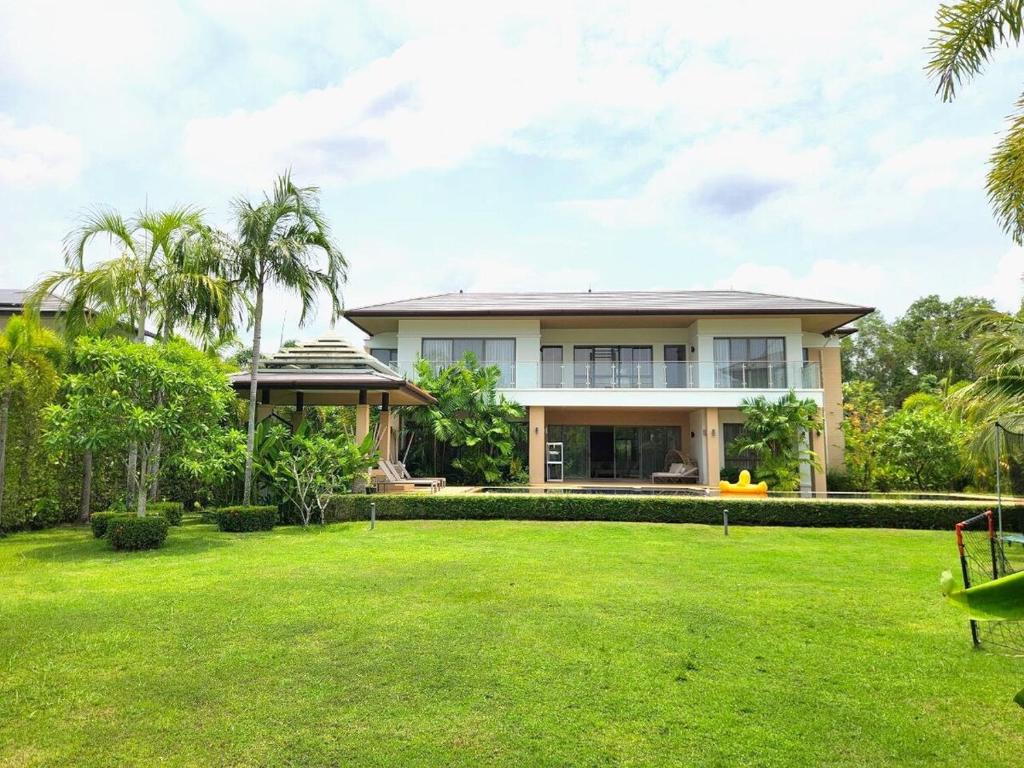 a house with a lawn in front of it at WEG Laguna Residence in Thalang