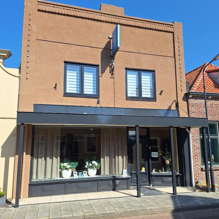 a store front of a brick building with windows at Zeeuwse Zot in Wissenkerke