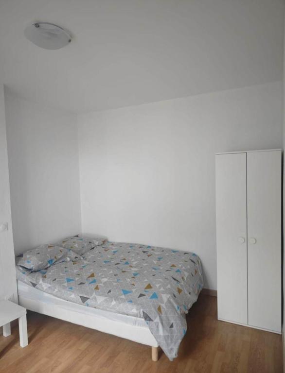 - une chambre blanche avec un lit et une armoire blanche dans l'établissement Séjour en ville, à Aubervilliers