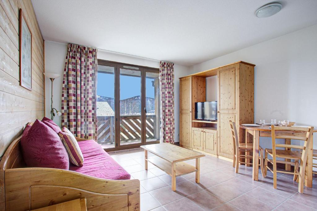 ein Wohnzimmer mit Couch und Tisch und eine Küche in der Unterkunft L'Escapade aux Angles - Proche Stations in Les Angles