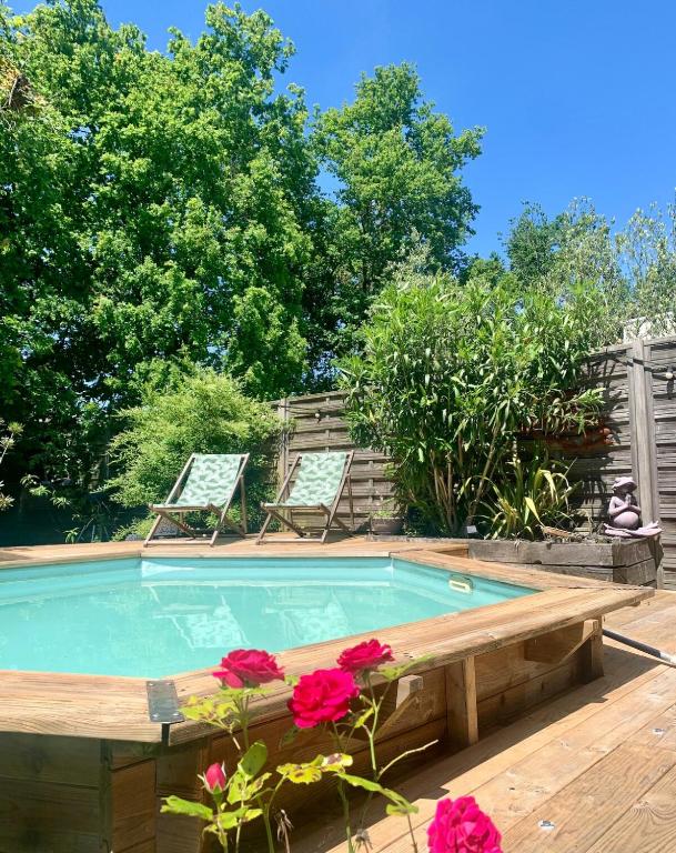 - une piscine avec 2 chaises longues et des fleurs dans l'établissement Charming quiet house in Bordeaux, à Bordeaux