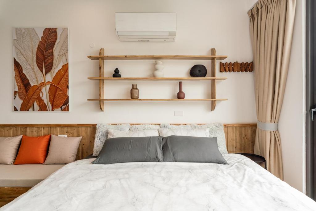 um quarto com uma cama e prateleiras na parede em Homestay CHẤT- Train Street,Self check em Hanói