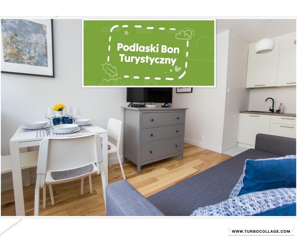 a living room with a table and a kitchen at CR Kameralny Apartament przy Pałacu Branickich in Białystok