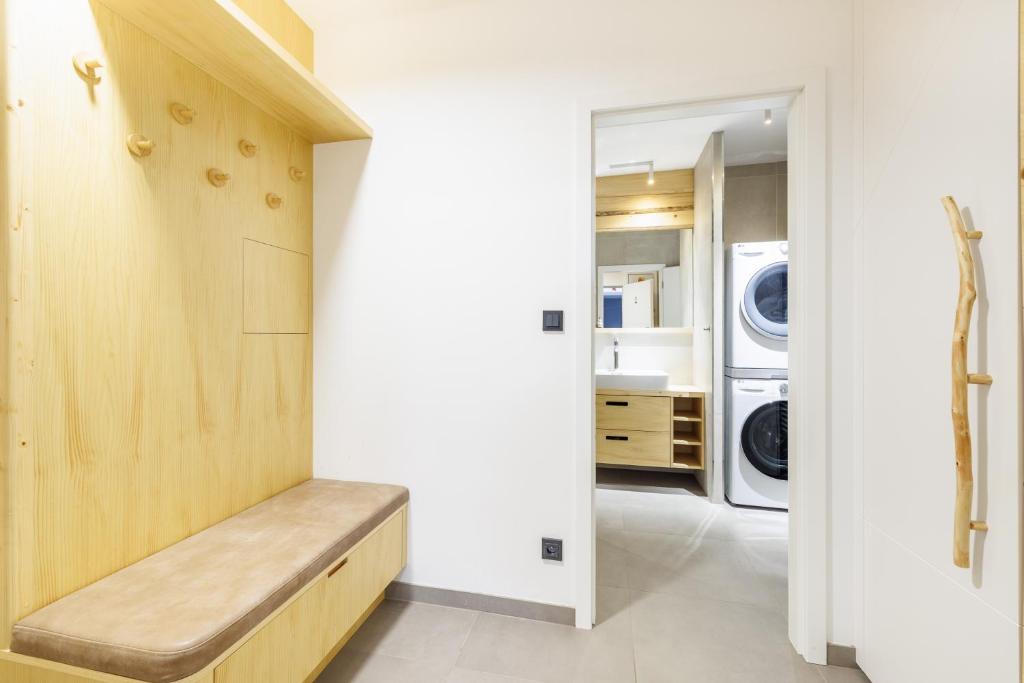 a laundry room with a bench and a washer and dryer at Jasmínový Ráj in Vítkovice