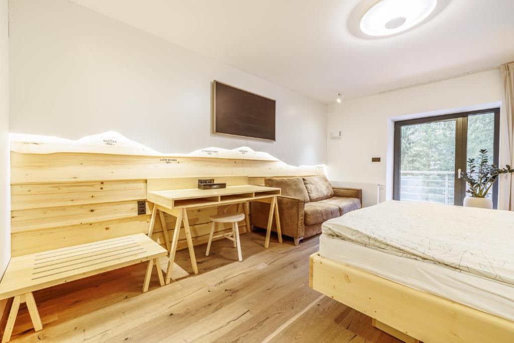a bedroom with two beds and a desk and a couch at Jasmínový Ráj in Vítkovice
