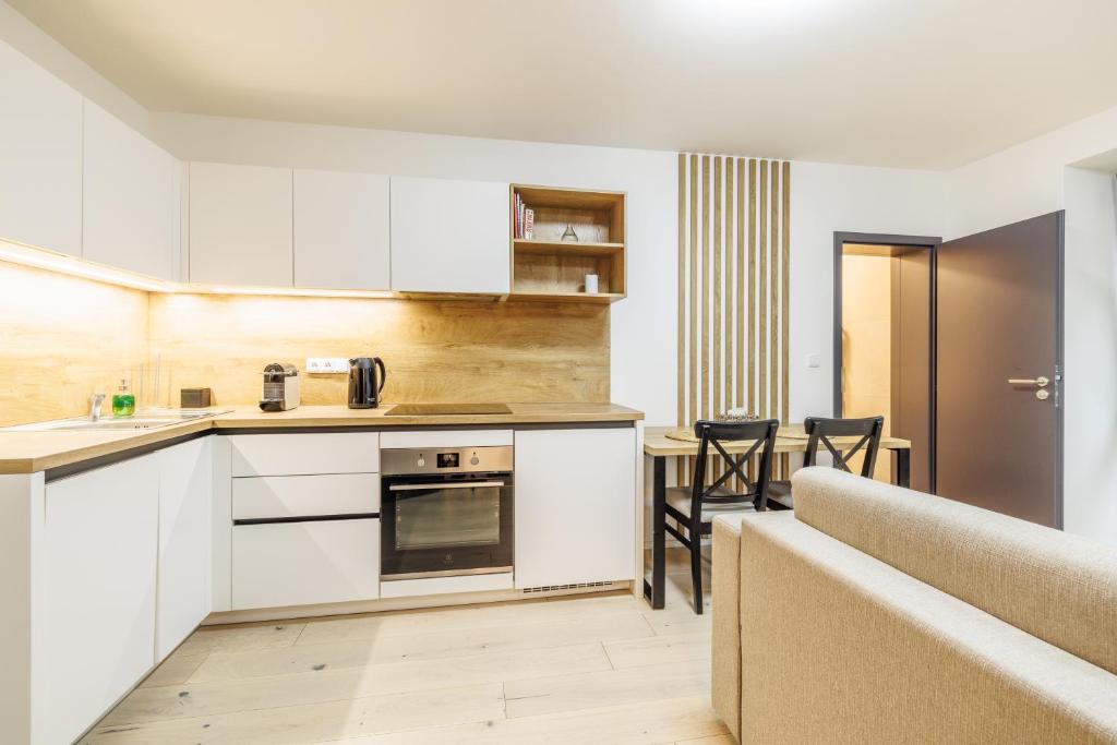 a kitchen with white cabinets and a table and chairs at Jasmínový Ráj in Vítkovice